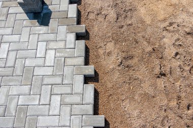 Evin girişine gri beton döşeme döşeme döşemesi. Kaldırım döşenmiş tuğlalı kaldırım inşaatı, yarı döşenmiş kaldırım yolu.