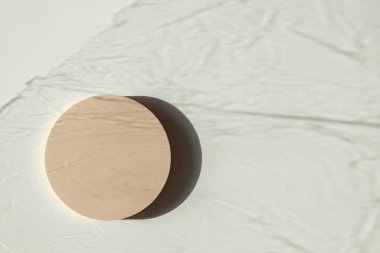 Beyaz zemin üzerinde doğal ışık ve gölgelerle dolu, boş, pastel bej bir platform podyumu. Kozmetik ürün sunumu için arka planı düzenle. Üst görünüm