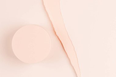 Yırtık kağıt arkaplanda kozmetik ürün sunumu için boş yuvarlak pastel bej platform podyumu. Üst görünüm