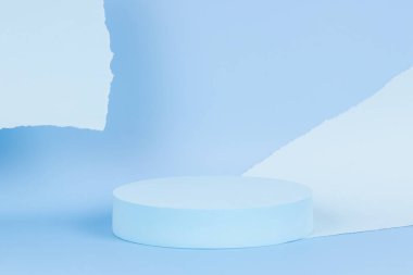 Ürün sunumu için boş yuvarlak podyum platformu ve açık mavi arkaplanda yırtık kağıt kenarlı soyut monokrom kompozisyonu. Ön görünüm
