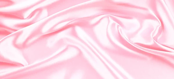 Beautiful pastel pink background with drapery and wavy folds of silk satin material texture. Top view — Stock Photo, Image