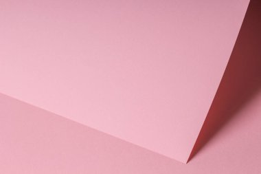 Gölgeli, boş, pastel, pembe kağıt kağıtlı bir not. Metin için kopyalama alanı olan soyut geometrik monokrom pembe arkaplan. Ön köşegen görünüm