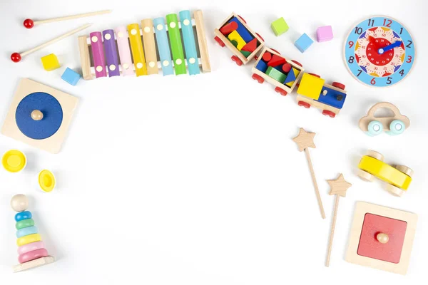 Brinquedos educativos e musicais de madeira coloridos para crianças pequenas em fundo branco. Vista superior, quadro de leigos plano — Fotografia de Stock