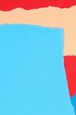 Kolaj arka planında yırtık kağıt var. Grunge, geometrik mavi ve kırmızı arka planda yırtık kenarlı pastel kağıt parçaları yırttı.