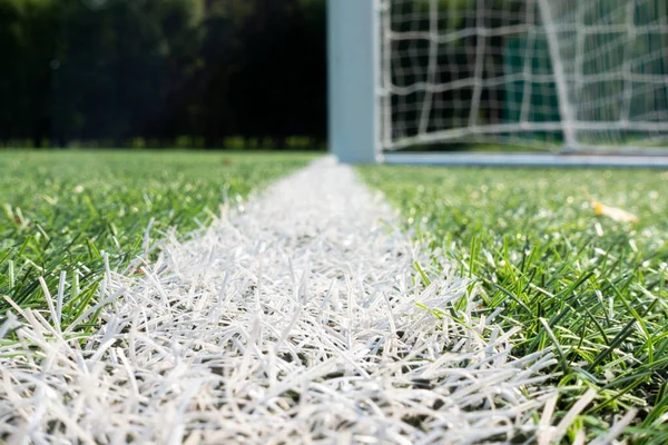 Αθλητικό υπόβαθρο. Close up to white line on green τεχνητό γρασίδι χλοοτάπητα γήπεδο ποδοσφαίρου με πύλη — Φωτογραφία Αρχείου