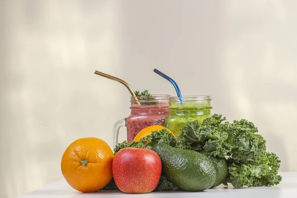 Healthy drink coctail smoothie in glass jars with fresh green kale leaves, avocados, apple, orange on white table. Healthy vegan vegetarian food — Stock Photo, Image