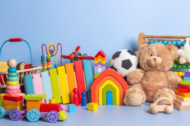 Bebek oyuncak koleksiyonu mavi arka planda izole edilmiş. Oyuncak ayı, tahta, plastik ve tüylü oyuncak seti. Ön görünüm