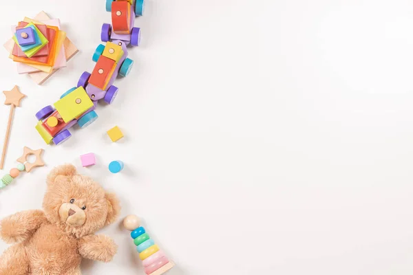 Bebê crianças brinquedos quadro no fundo branco. Urso de pelúcia e muitos brinquedos de madeira educativos Montessori coloridos. Vista superior, flat lay — Fotografia de Stock