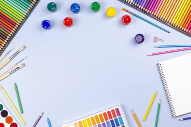 Yaratıcı sanat eserleri arka planda. Suluboya, fırça, kalem, mavi arka planda defter. Üst manzara, düz uzanma
