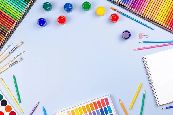 Yaratıcı sanat eserleri arka planda. Suluboya, fırça, kalem, mavi arka planda defter. Üst manzara, düz uzanma