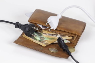 Elektrik şebekesi kablo kablolarını açık cüzdana takıp Euro parasıyla çalıştırıyor. Elektrik faturaları. Artan elektrik maliyeti ve pahalı enerji kavramı