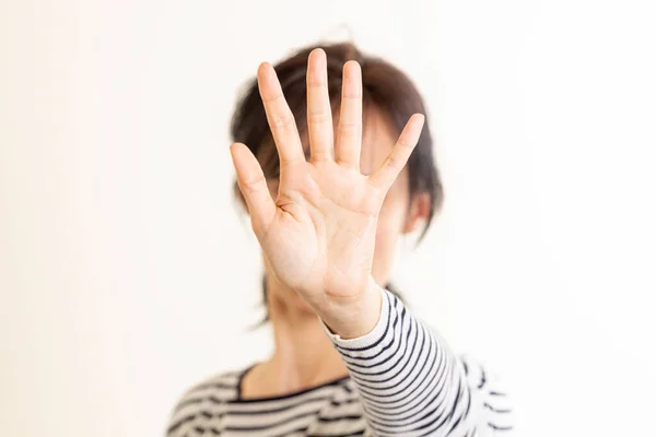 Gestos de mano Detente, No. La mujer levanta la mano, cubriéndose la cara y muestra un gesto de parada a mano tratando de detener cualquier peligro que se avecina. Signo de lenguaje no verbal — Foto de Stock