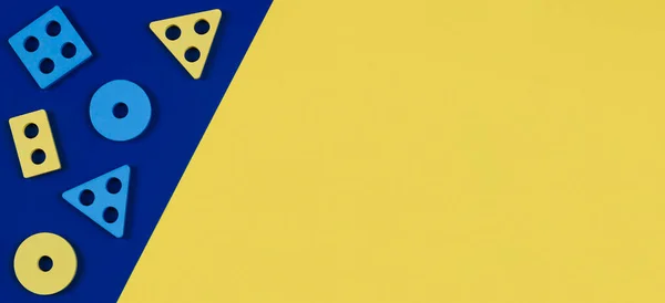 Vista superior para blocos de madeira forma classificador de peças de brinquedo no fundo de cor amarela e azul. Crianças educativas Montessori brinquedos de madeira. Desenvolvimento da primeira infância — Fotografia de Stock