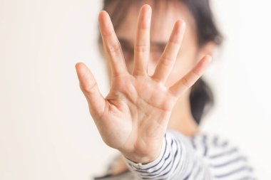 El hareketi. Dur, hayır. Kadın elini kaldırır, yüzünü kapatır ve gösterir yaklaşan tehlikeyi durdurmak için el hareketlerini durdurur. Sözsüz dil işareti