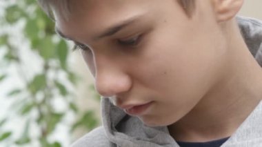 Hüzünlü genç çocuk başını eğip yana baktı ve başını kaldırdı. 4k video