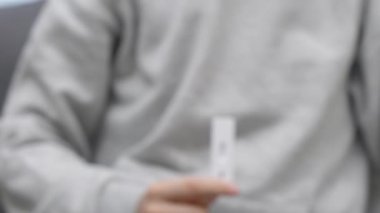 Coronavirus salgını koruması. Ergen, evde kendini test etmek için hızlı antijen test kiti kullanıyor. Test şeridinde Covid-19 negatif test sonuçlarını gösteren çocuk eli
