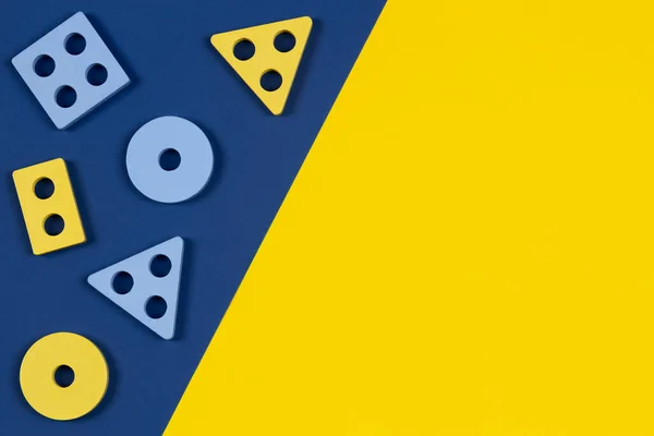 Felülnézetből fa blokkok alakja válogató játék alkatrészek sárga és kék színű háttér. Childrens oktatási Montessori fából készült játékok. Koragyermekkori fejlődés — Stock Fotó