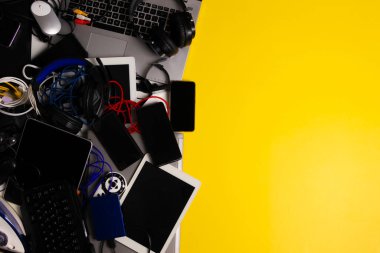 Eski bilgisayarlar, dijital tabletler, cep telefonları, pek çok kullanılmış elektronik cihazlar, bozuk ev aletleri ve sarı arka plandaki aletler. Geri dönüşüm konsepti için planlanmış eskitme, elektronik atık