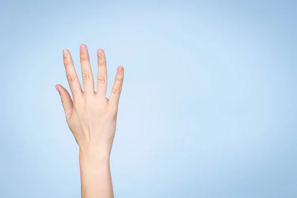 La mano femenina muestra el número cinco. Mano de mujer mostrando cinco dedos, señalando con los dedos hacia arriba sobre fondo azul claro — Foto de Stock