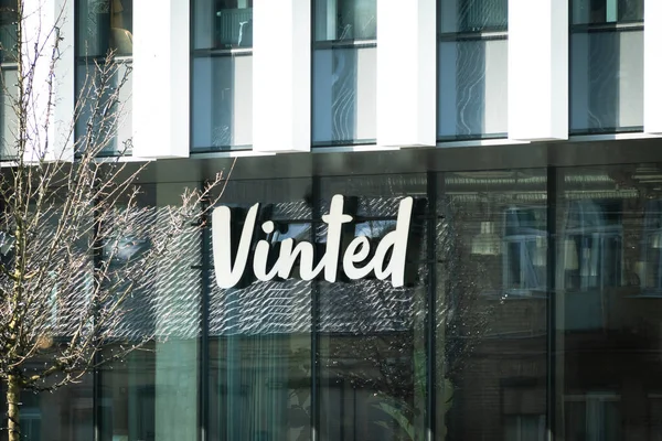 Vilnius, Lituania - 25 de marzo de 2022: Cartel con el logotipo de Vinted en la pared del edificio de oficinas. Vinted es un mercado en línea para comprar, vender e intercambiar artículos nuevos o de segunda mano, principalmente ropa y accesorios. — Foto de Stock