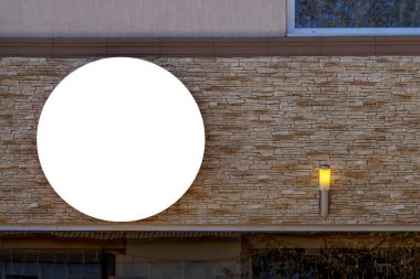 Mock up. Empty round white signage of shop, store, restaurant, office on building wall in the city