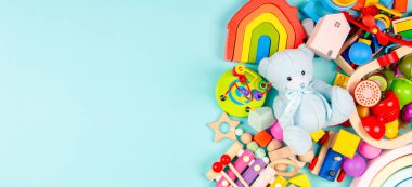 Bebek oyuncakları açık mavi arka planda. Renkli eğitici ahşap ve müzikal oyuncaklar. Üst manzara, düz uzanma