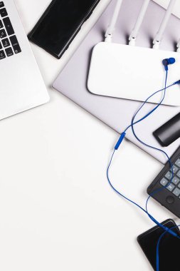 Üst görüntüden eski dizüstü bilgisayara, cep telefonuna, beyaz masadaki birçok kullanılmış elektronik cihaza. Geri dönüşüm konsepti için planlanmış eskitme, e-atık, elektronik atık