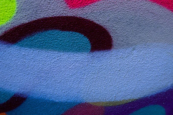 거리에는 다채 로운 낙서 그림이 그려진 벽의 일부가 있었다. 벽에 붙어 있는 다채 로운 거리 벽화의 일부 — 스톡 사진
