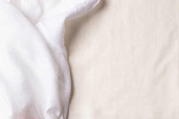 White crumpled linen fabric texture background. Natural linen organic eco textiles canvas background. Two shades of white color linen cloth material. Top view