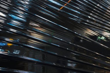 Siyah plastik ambalaj. Buruşmuş plastik selofan kırışıklığı. Plastik yüzeydeki kıvrımlara ve kıvrımlara ışığı ve gölgeyi yansıtıyor. Doku kaplama efekti şablonu.