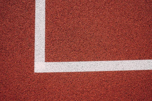 Colorful sports court background. Top view to red field rubber ground with white lines outdoors