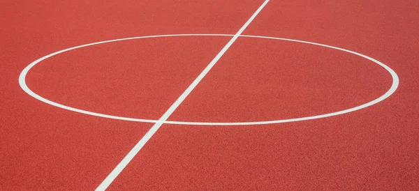 Sports court background. Top view to red artificial rubber ground with central circle field line with copy space.