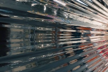 Siyah plastik ambalaj. Buruşmuş plastik selofan kırışıklığı. Plastik yüzeydeki kıvrımlara ve kıvrımlara ışığı ve gölgeyi yansıtıyor. Doku kaplama efekti şablonu.