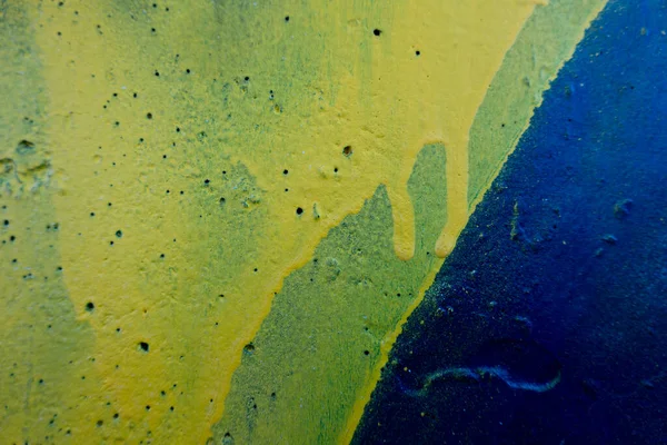 Blue and yellow painted concrete with leaking traces of paint. Abstract old grunge wall texture background.