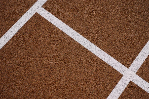 Colorful sports court background. Top view to red field rubber ground with white lines outdoors