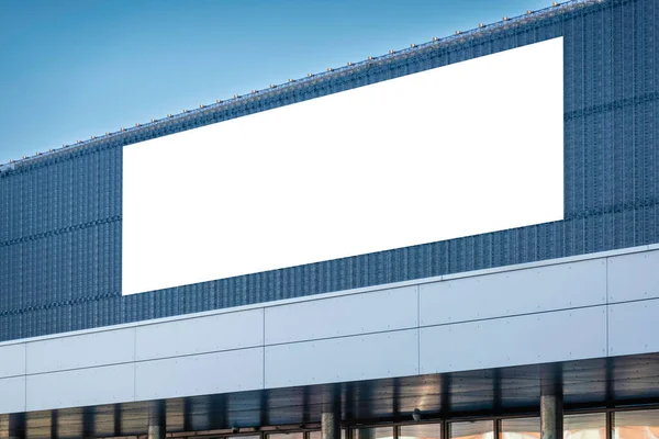 Mock up template. Big horizontal white blank signboard, advertising billboard on modern building wall outdoors.