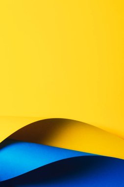 Sarı ve mavi kağıtların soyut dalgası. Işık ve gölgeli yaratıcı geometrik kavisli kağıt. Kopya alanı ile soyut geometri arkaplanı