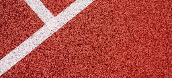 Colorful sports court background. Top view to red field rubber ground with white lines outdoors.