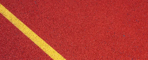 Colorful sports court background. Top view to red field rubber ground with yellow corner lines outdoors.