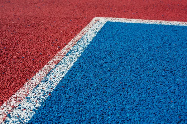 Colorful sports court background. Top view to red and blue field rubber ground with white lines outdoors.