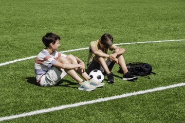 Teenage boy comforting consoling upset sad friend in school stadium. Education, bullying, conflict, social relations, problems at school, learning difficulties concept.