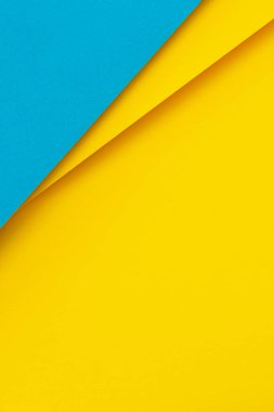 Abstract color papers geometry flat lay composition background with light blue and bright yellow tones.
