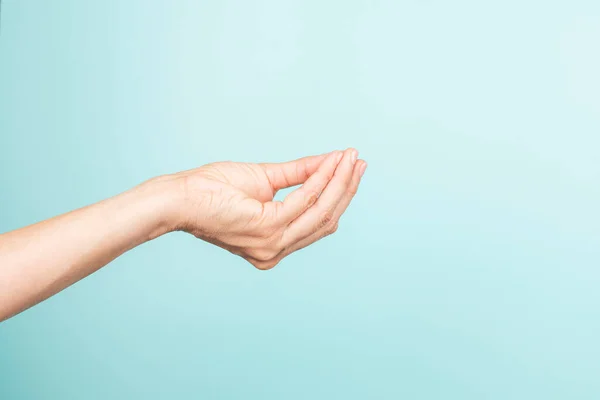 Italian hand gesture. Woman right hand Italian gesture on light blue background. Front view, copy space.