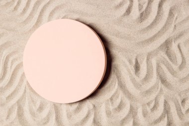 Kozmetik ürünleri için boş bej yuvarlak platform podyumu ya da doğal bej plaj kum arka planı sunumu. Dalgalı kıvrımlı süsler, elle çizilmiş. Üst görünüm.