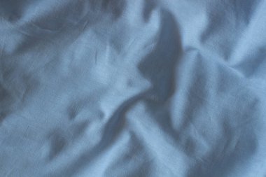 Soyut buruşmuş keten kumaş dokusu arka planı. Doğal maviye boyanmış keten organik eko tekstil tuval arka plan. Üst görünüm.