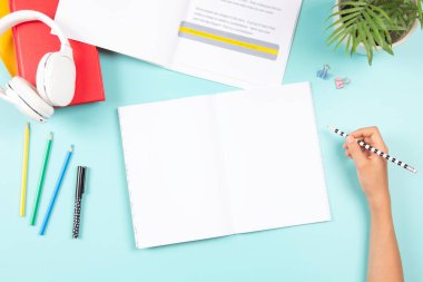 Çocuk ödev yapıyor, renkli kaplama şeritler kullanarak kitap okuyor. Kitaplar ve okul malzemeleriyle üst kattan masaya. Eğitim, öğrenme güçlüğü, okuma güçlüğü.