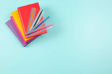 Dyslexia. Top view to red book with different colors reading highlight bookmark overlays strips on light blue background. Reading rulers overlays, tools to help reading for people with dyslexia.