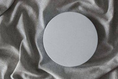 Güzellik kozmetiği için boş, yuvarlak podyum platformu ya da doğal gri keten kumaş arka planı sunumu. Üst görünüm.