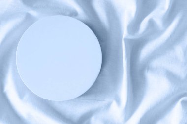 Güzellik kozmetik ürünleri için boş yuvarlak podyum platformu ya da doğal açık mavi keten kumaş arka planı sunumu. Üst görünüm