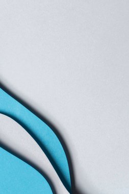 Soyut renkli kağıt dokusu arkaplanı. Asgari kağıt, geometrik şekil katmanları ve mavi renk çizgileriyle stil kompozisyonu keser. Üst görünüm.